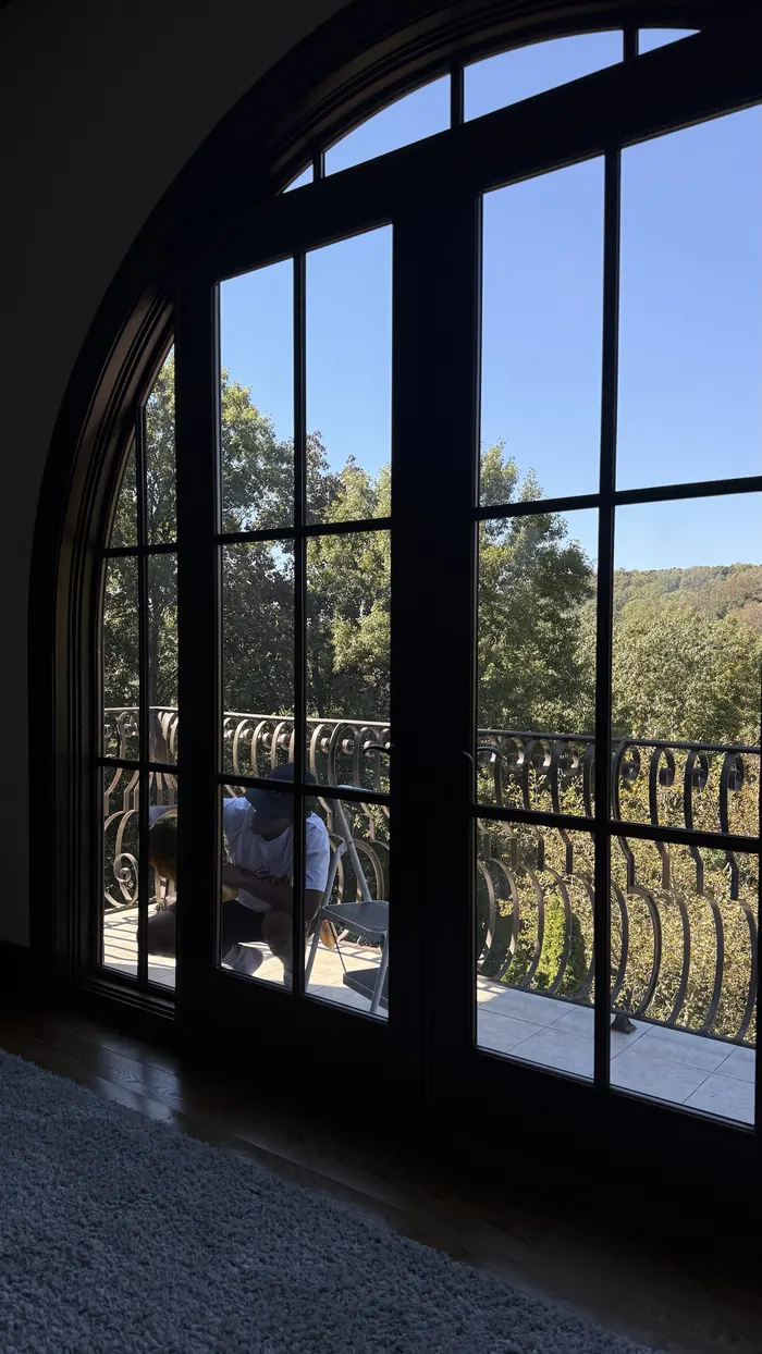View through clean arched windows to a wooded hillside