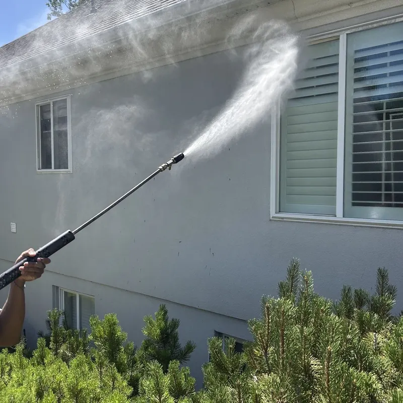 Washing stucco siding beside a window